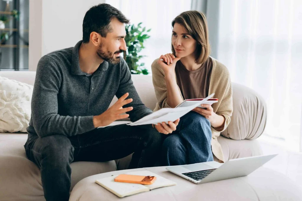 Couple discussing home finances and budget planning.