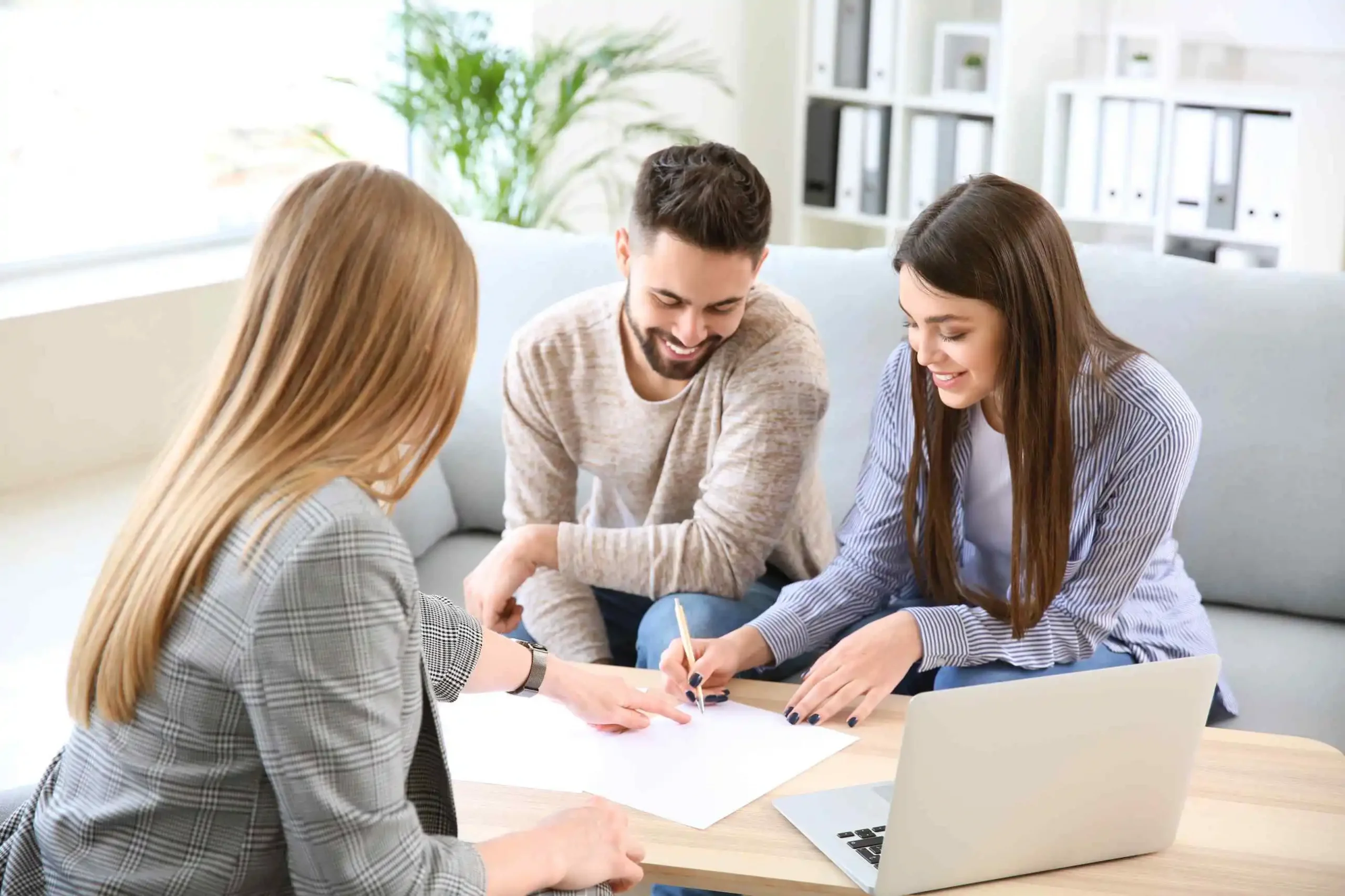 Young couple meeting with real estate agent for home buying.